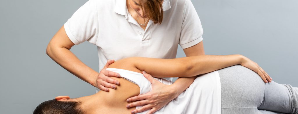 female osteopath treating patient's shoulder blades